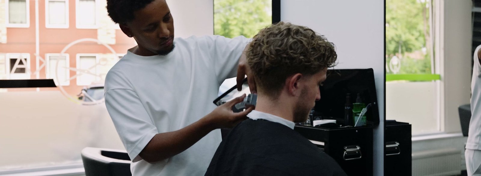 Een kapper knipt een klant in zijn zaak