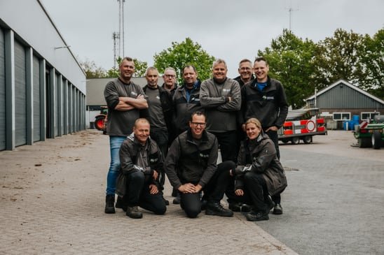 Een team in werkjassen voor hun bedrijfspand, gefotografeerd door StudioMieke
