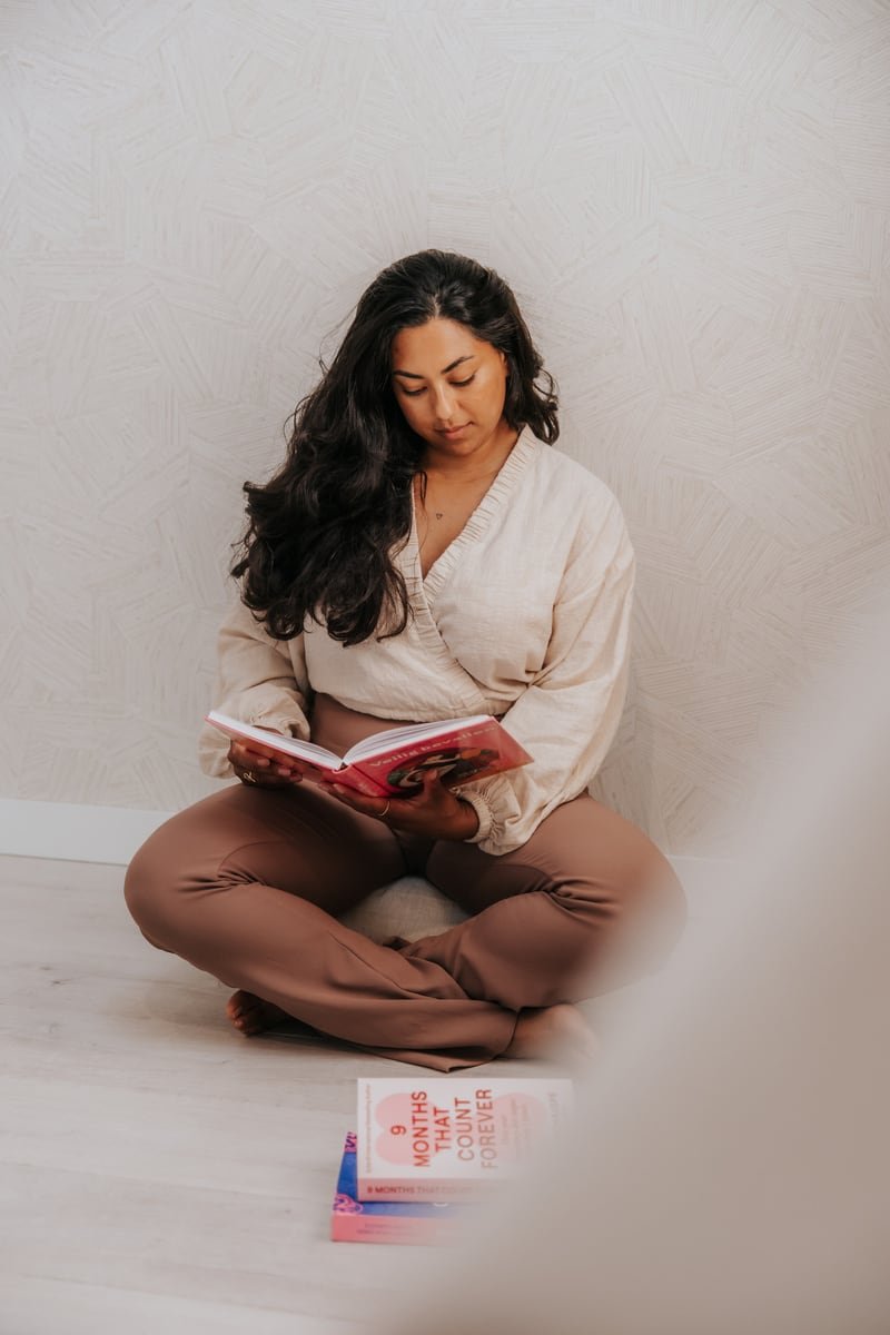 Een vrouw leest op de vloer van haar praktijk, gefotografeerd door StudioMieke