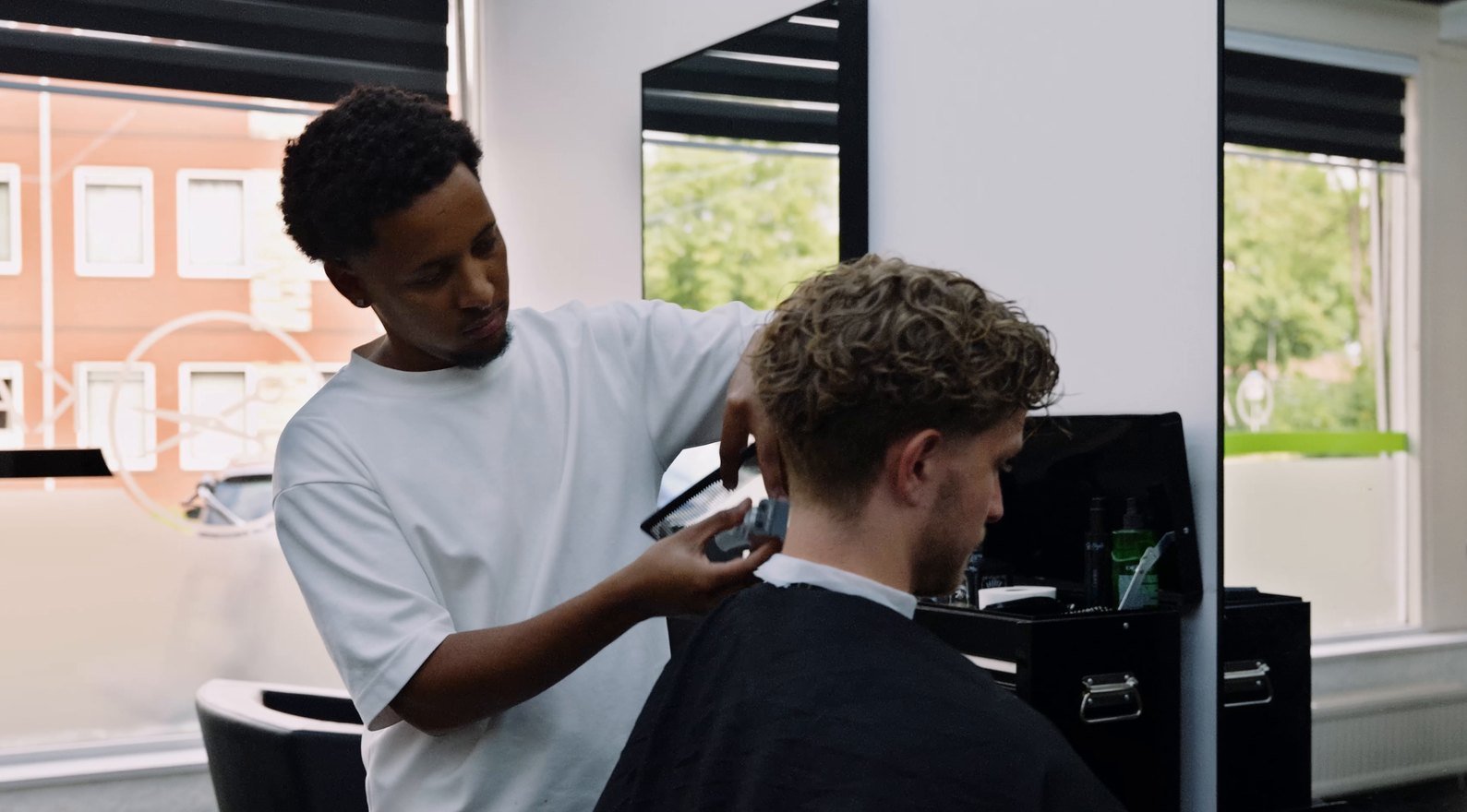 Een kapper knipt een klant, gefilmd voor de bedrijfsvideo van Websaites