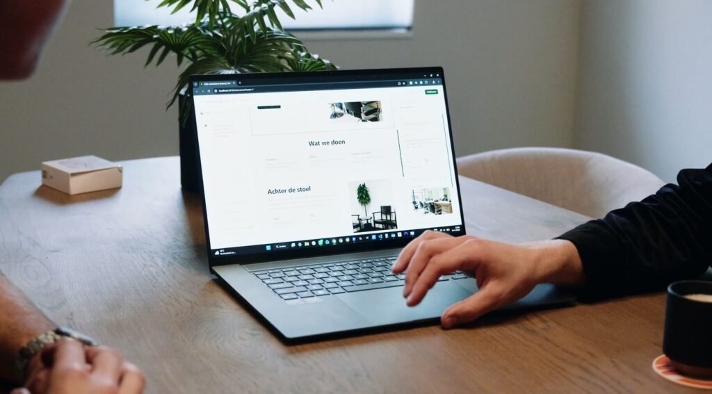 Iemand werkt aan tafel achter een laptop